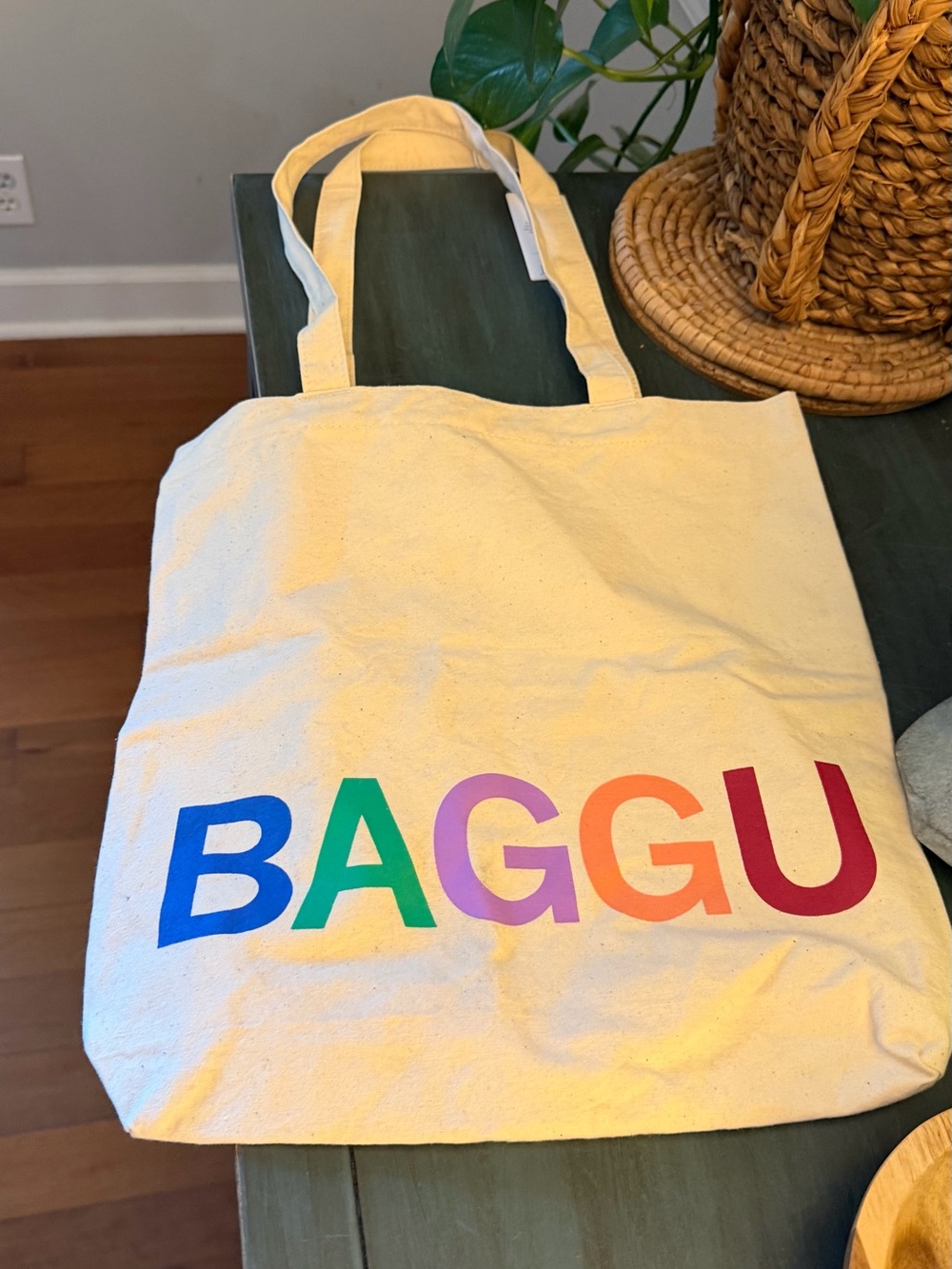 BAGGU Cream colored canvas Merch Tote with multicolored rainbow logo.